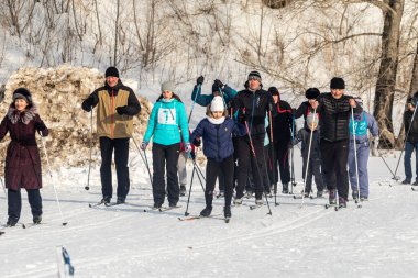 Petropavlovsk, Kazakistan - 29 Şubat 2020: Erkekler ve kadınlar, çocuklar kışın ormanda kayak yapıyor. Güneşli kış manzarası, kayak. Petropavlovsk, Kazakistan.