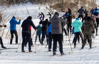 Petropavlovsk, Kazakistan - 29 Şubat 2020: Erkekler ve kadınlar, çocuklar kışın ormanda kayak yapıyor. Güneşli kış manzarası, kayak. Petropavlovsk, Kazakistan.