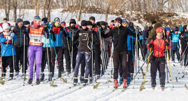 Petropavlovsk, Kazakistan - 29 Şubat 2020: Erkekler ve kadınlar, çocuklar kışın ormanda kayak yapıyor. Güneşli kış manzarası, kayak. Petropavlovsk, Kazakistan.