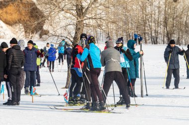 Petropavlovsk, Kazakistan - 29 Şubat 2020: Erkekler ve kadınlar, çocuklar kışın ormanda kayak yapıyor. Güneşli kış manzarası, kayak. Petropavlovsk, Kazakistan.