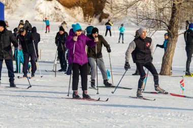 Petropavlovsk, Kazakistan - 29 Şubat 2020: Erkekler ve kadınlar, çocuklar kışın ormanda kayak yapıyor. Güneşli kış manzarası, kayak. Petropavlovsk, Kazakistan.