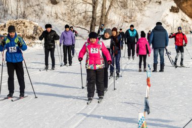 Petropavlovsk, Kazakistan - 29 Şubat 2020: Erkekler ve kadınlar, çocuklar kışın ormanda kayak yapıyor. Güneşli kış manzarası, kayak. Petropavlovsk, Kazakistan.