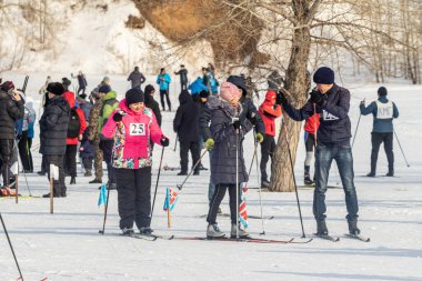 Petropavlovsk, Kazakistan - 29 Şubat 2020: Erkekler ve kadınlar, çocuklar kışın ormanda kayak yapıyor. Güneşli kış manzarası, kayak. Petropavlovsk, Kazakistan.