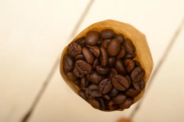 Chicchi di caffè espresso su un cono di carta — Foto Stock