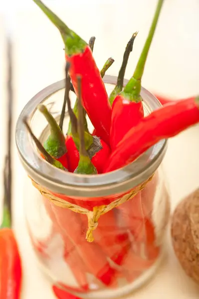 Red chili peppers on a glass jar — Stock Photo, Image