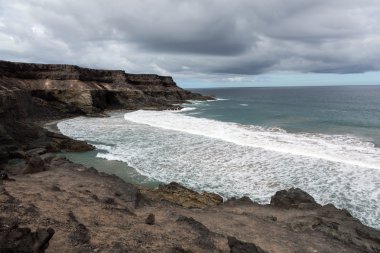 Puertito beach de los Molinos Fuerteventura üzerinde bir kayaya üzerine sıçramasına el salla. Kanarya Adaları, İspanya