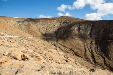 Güzel volkanik dağlar ve yolun bir dağ yamacında. La Pared yol Betancuria için. Fuerteventura. Kanarya Adaları