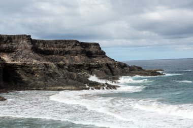 Puertito beach de los Molinos Fuerteventura üzerinde bir kayaya üzerine sıçramasına el salla. Kanarya Adaları, İspanya
