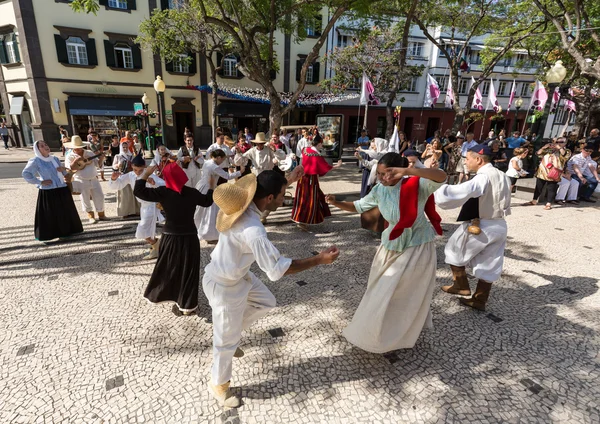 Bailarines con disfraces locales demostrando una danza folclórica durante el Festival del Vino en Funchal en la Madeira, Portugal . — Foto de Stock