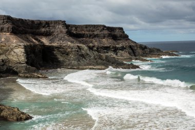 Puertito beach de los Molinos Fuerteventura üzerinde bir kayaya üzerine sıçramasına el salla. Kanarya Adaları, İspanya