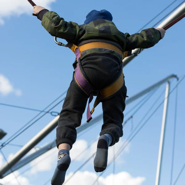 A gyerekek jó szórakozást a gumiszalaggal biztosított bungee trambulinon ugráláshoz. — Stock Fotó