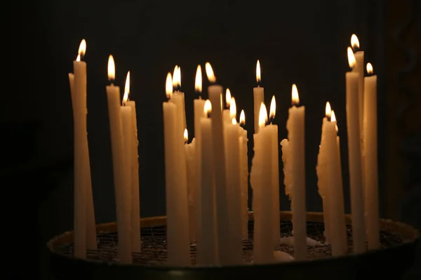 Kerzen im Dunkeln einer Kirche — Stockfoto