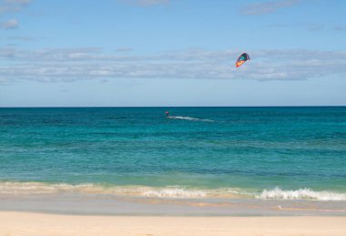 Bilinmeyen kitesurfer Corralejo, Fuerteventura, Kanarya Adaları, İspanya Atlas Okyanusu'nda düz masmavi bir su üzerinde sörf