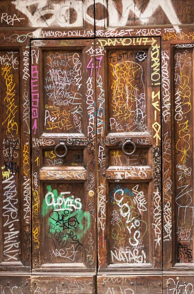 Alte Holztür im Trastevere-Viertel mit Graffiti beschmiert. rom, italien. — Stockfoto
