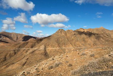 Güzel volkanik dağlar ve yolun bir dağ yamacında. La Pared yol Betancuria için. Fuerteventura. Kanarya Adaları