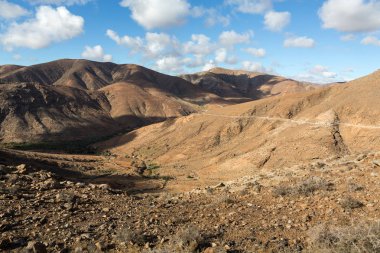 Güzel volkanik dağlar ve yolun bir dağ yamacında. La Pared yol Betancuria için. Fuerteventura. Kanarya Adaları