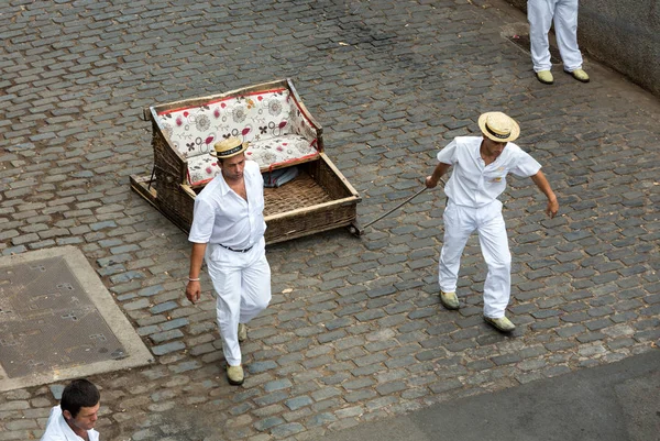 Los jinetes del tabaco que mueven el trineo tradicional de la caña cuesta abajo en las calles de Funchal. Parque de Monte, Isla de Madeira, Portugal —  Fotos de Stock