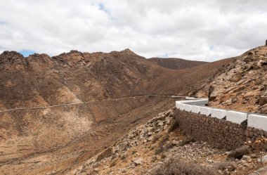 Güzel volkanik dağlar ve yolun bir dağ yamacında. La Pared yol Betancuria için. Fuerteventura. Kanarya Adaları