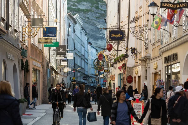 Niezidentyfikowanych ludzi chodzących na słynne historyczne handlowej ulicy Getreidegasse w Salzburgu. Getreidegasse, jest jedną z najstarszych ulic w mieście Salzburg — Zdjęcie stockowe