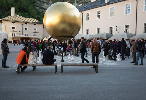 Stephan Balkenhol - Sphaera, una escultura de un hombre en una esfera dorada en Kapitelplatz en Salzburgo, Austria — Foto de Stock
