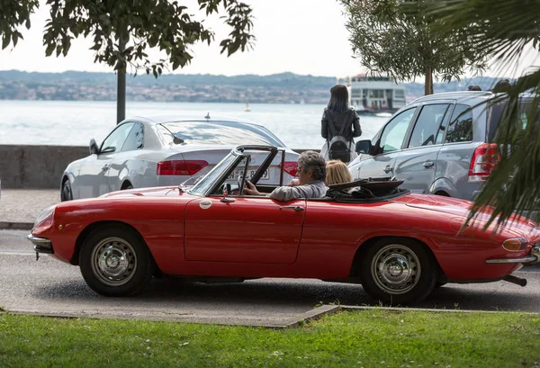 Cuplu în cabriolet roșu de epocă Alfa Romeo Giulietta Spider — Fotografie, imagine de stoc