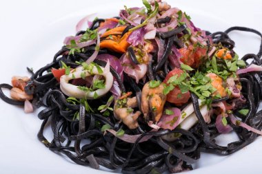 Deniz ürünleri ve sebze ile siyah spagetti