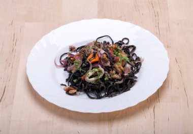 Deniz ürünleri ve sebze ile siyah spagetti