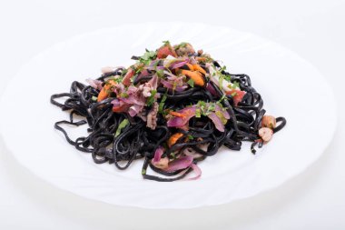 Deniz ürünleri ve sebze ile siyah spagetti.