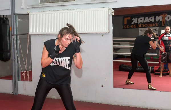 Boxeador durante el entrenamiento de boxeo con entrenador en el gimnasio . — Foto de Stock