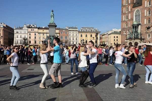 Día Internacional de Flashmob de Rueda de Casino, 57 países, 160 ciudades. Varios cientos de personas bailan ritmos hispanos en la Plaza Principal de Cracovia . — Foto de Stock