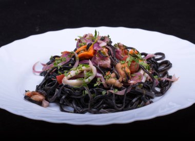 Deniz ürünleri ve sebze ile siyah spagetti