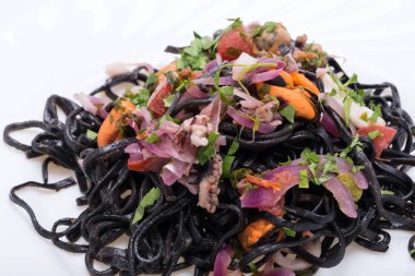 Deniz ürünleri ve sebze ile siyah spagetti