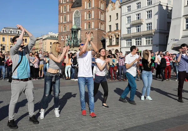 International Flashmob Day of Rueda de Casino, 57 countries, 160 cities. Several hundred persons dance Hispanic rhythms on the Main Square in Cracow. — Stock Photo, Image