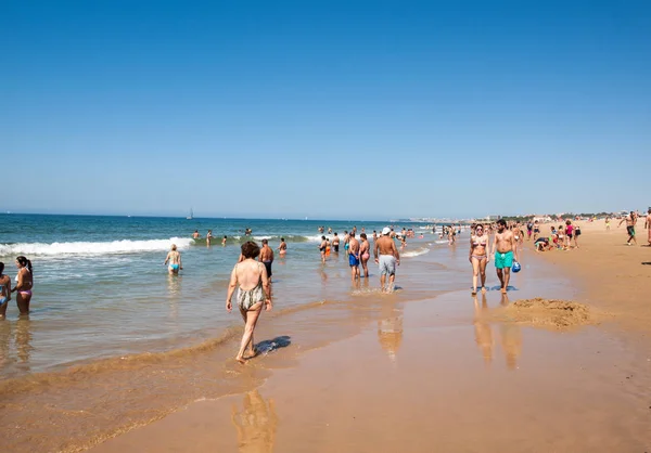 Personas tomando el sol en la playa de Cascais, Portugal. Cascais es famoso y popular lugar de vacaciones de verano para los turistas portugueses y extranjeros —  Fotos de Stock