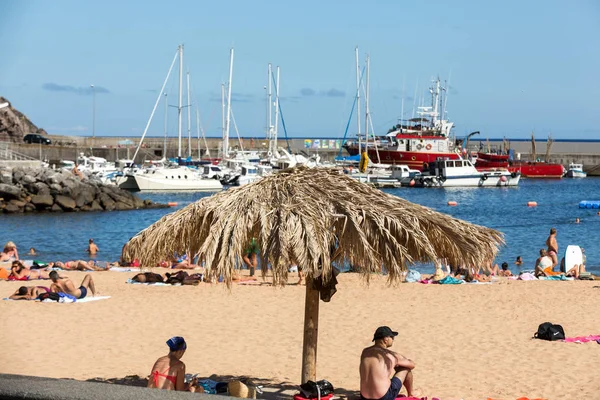 Ludzie są odpoczynku w słoneczny dzień na plaży w mieście Machico. Wyspa Madera, Portugalia. — Zdjęcie stockowe