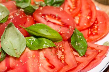 Fesleğenli domates dilimlenmiş.