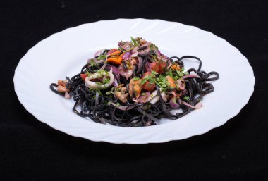 Deniz ürünleri ve sebze ile siyah spagetti