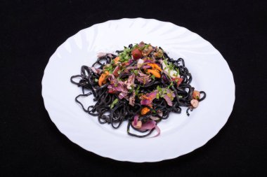 Deniz ürünleri ve sebze ile siyah spagetti.