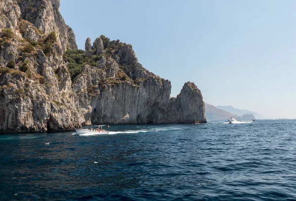 Vista dalla barca sulle Barche con i turisti e la costa scogliera dell'Isola di Capri. Italia — Foto Stock