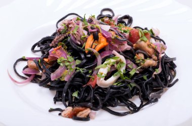 Deniz ürünleri ve sebze ile siyah spagetti