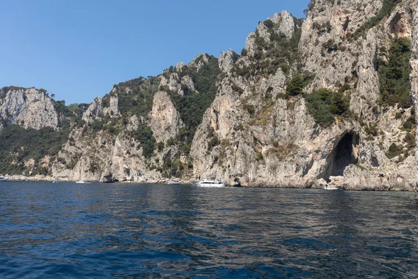 Vista dalla barca sulle Barche con i turisti e la costa scogliera dell'Isola di Capri — Foto Stock