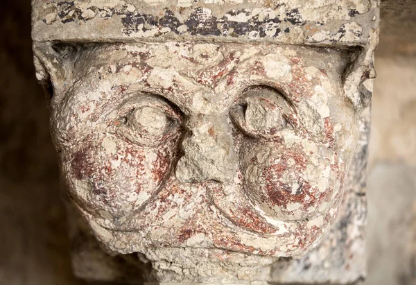 Romaanse Carving van een vreemd hoofd of gezicht (c12th) kapitaal in de kloosters van de abdij van de Montmajour in de buurt van Arles Provence Frankrijk — Stockfoto