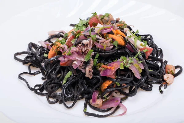 Deniz ürünleri ve sebze ile siyah spagetti