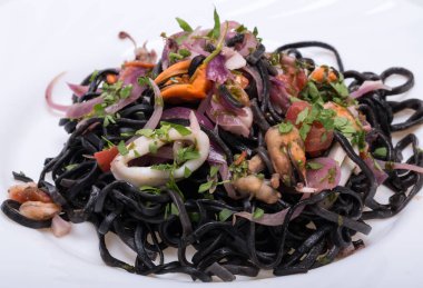 Deniz ürünleri ve sebze ile siyah spagetti