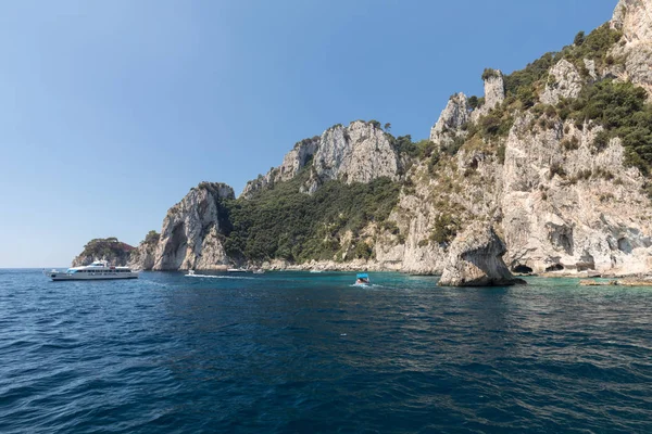 查看从船上船的游客与悬崖海岸的卡普里岛。意大利 — 图库照片