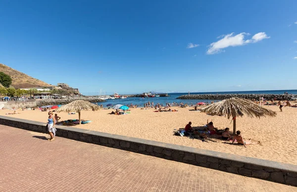 Ludzie są odpoczynku w słoneczny dzień na plaży w mieście Machico. Wyspa Madera, spokojne — Zdjęcie stockowe
