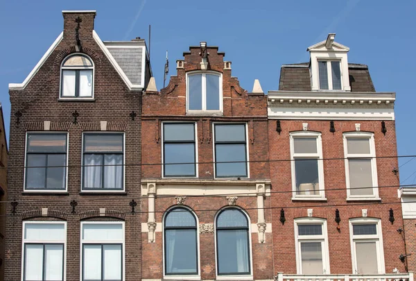 Casas típicas a dos aguas en la calle Damrak en Amsterdam, Holanda, Países Bajos — Foto de Stock