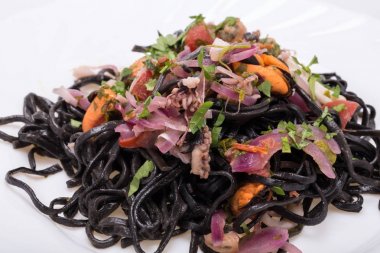 Deniz ürünleri ve sebze ile siyah spagetti