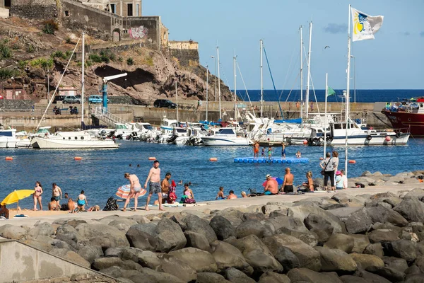 Ludzie są odpoczynku w słoneczny dzień na plaży w mieście Machico. Wyspa Madera, Portugalia — Zdjęcie stockowe