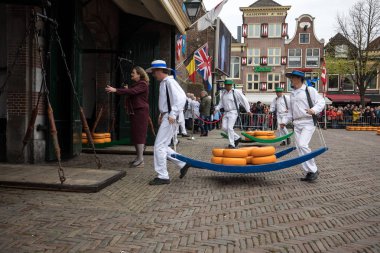 Alkmaar, Hollanda - 21 Nisan 2017: Alkmaar, Hollanda ünlü Hollandalı peynir pazarında birçok peynir ile yürüyüş uçak gemisi. Waagplein Meydanı'nda olay olur. 